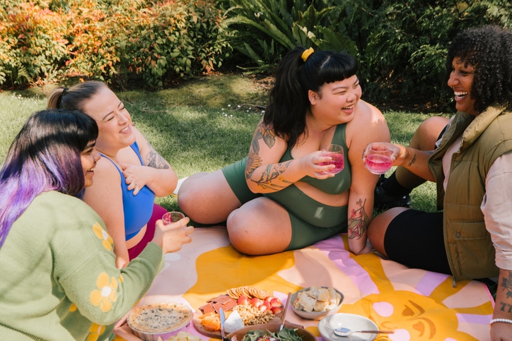 Friends having a picnic in a park together Health Care Professional standing in modern clinic